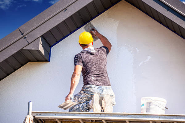 Ouvrier appliquant un enduit de ravalement de façade